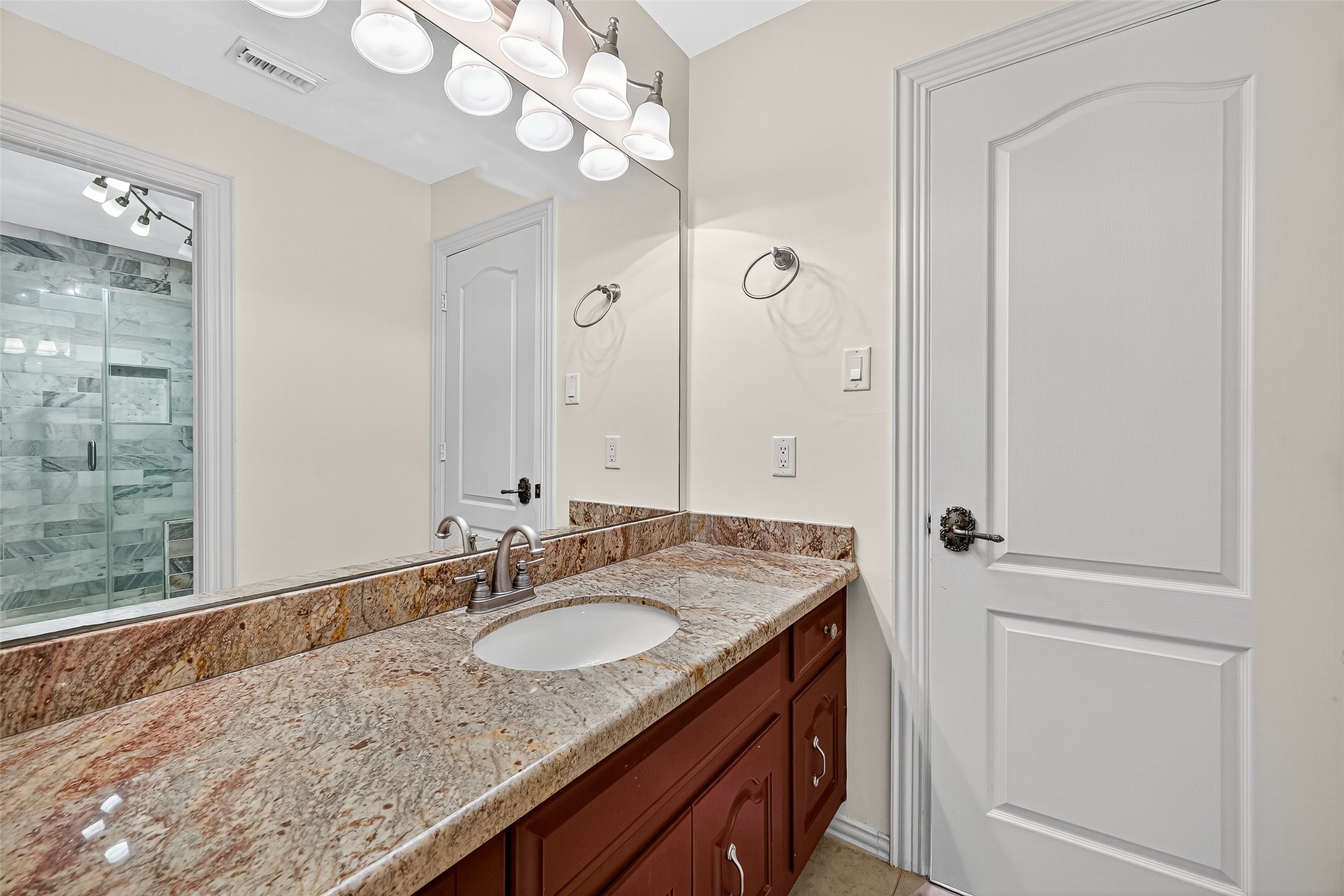 1803 Cottage Landing Lane Houston, TX 77077 - Photo 27 of 50 a bathroom with a granite countertop sink a mirror and a shower