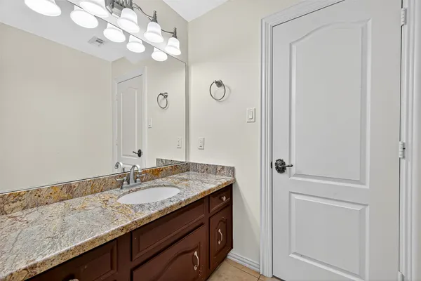 a bathroom with a granite countertop sink and a mirror