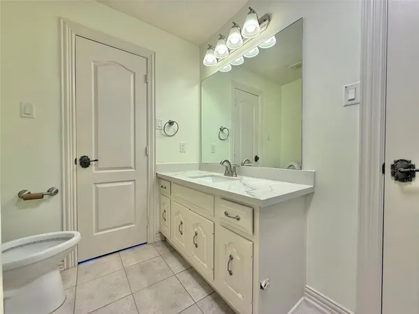 a bathroom with a granite countertop sink a toilet and shower
