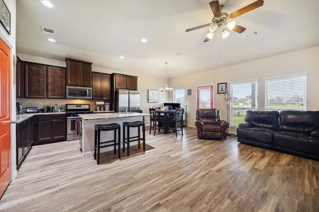 a living room with stainless steel appliances kitchen island granite countertop furniture and a kitchen view