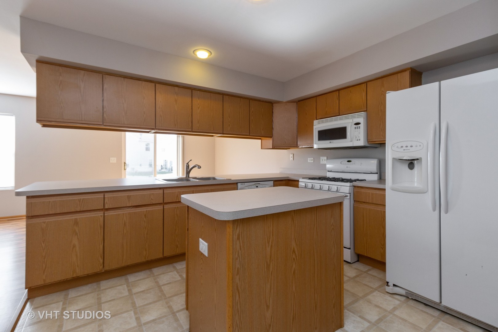 25192 Faraday Road Manhattan, IL 60442 - Photo 5 of 14 a kitchen with kitchen island a sink appliances and cabinets