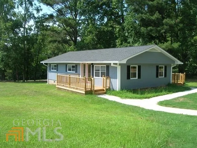 a front view of a house with a yard and green space
