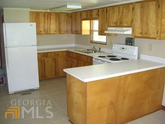 a kitchen with a refrigerator a sink a stove and white cabinets