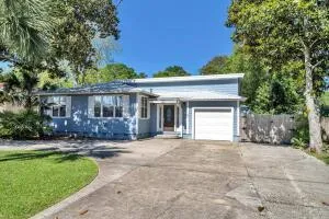 a front view of a house with a garden and trees