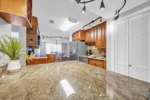 a kitchen with stainless steel appliances granite countertop a stove a sink and a refrigerator