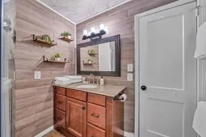 a bathroom with a granite countertop sink a mirror and shower