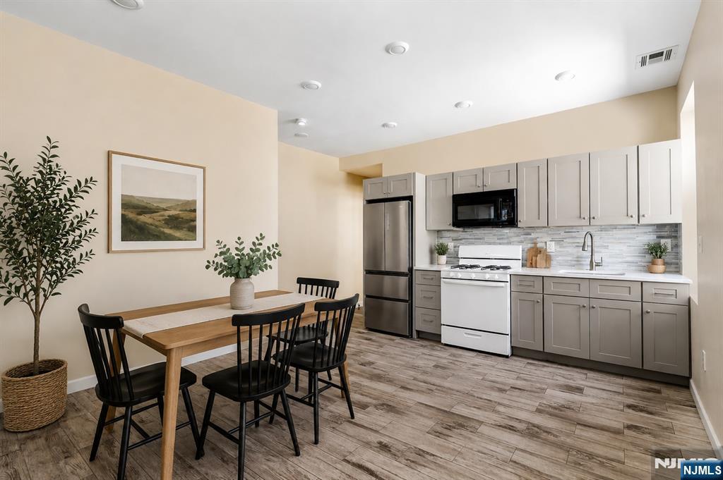 183 Bergen Turnpike Ridgefield Park, NJ 07660 - Photo 5 of 18 a kitchen with microwave a sink table and chairs
