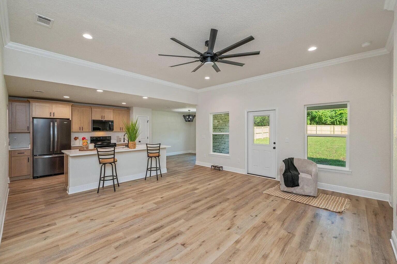 693 Bowers Avenue East Crestview, FL 32539 - Photo 6 of 27 a living room with stainless steel appliances kitchen island granite countertop furniture and a wooden floor