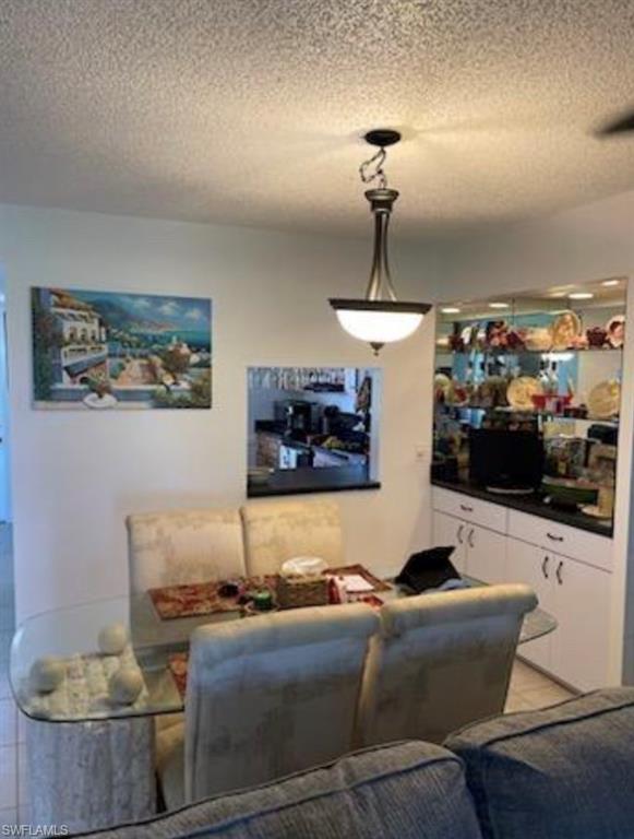 163 Palm Drive, Unit 2878 Naples, FL 34112 - Photo 6 of 14 a living room with furniture and a chandelier