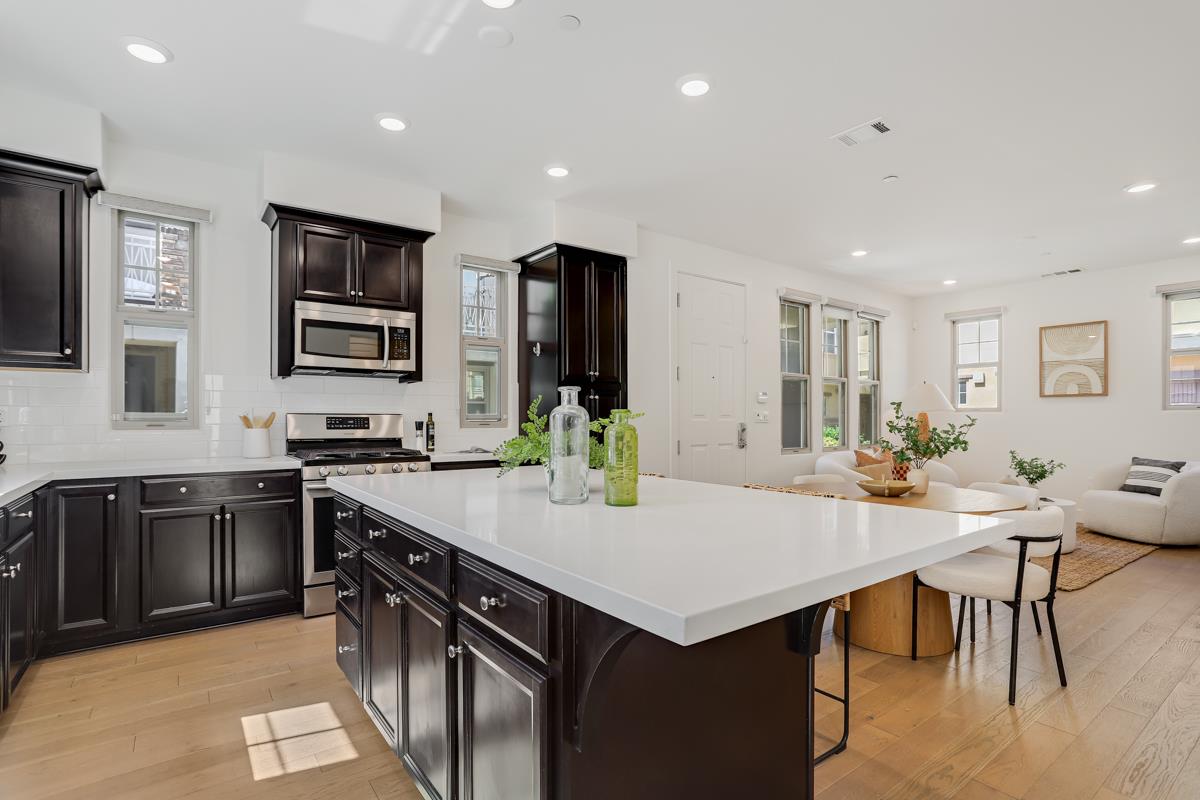 14 Catania Common Fremont, CA 94536 - Photo 15 of 39 a kitchen with stainless steel appliances granite countertop a stove a sink a microwave a dining table and chairs
