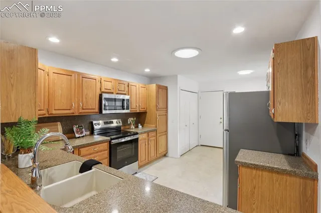 a kitchen with granite countertop a sink a counter top space appliances and cabinets