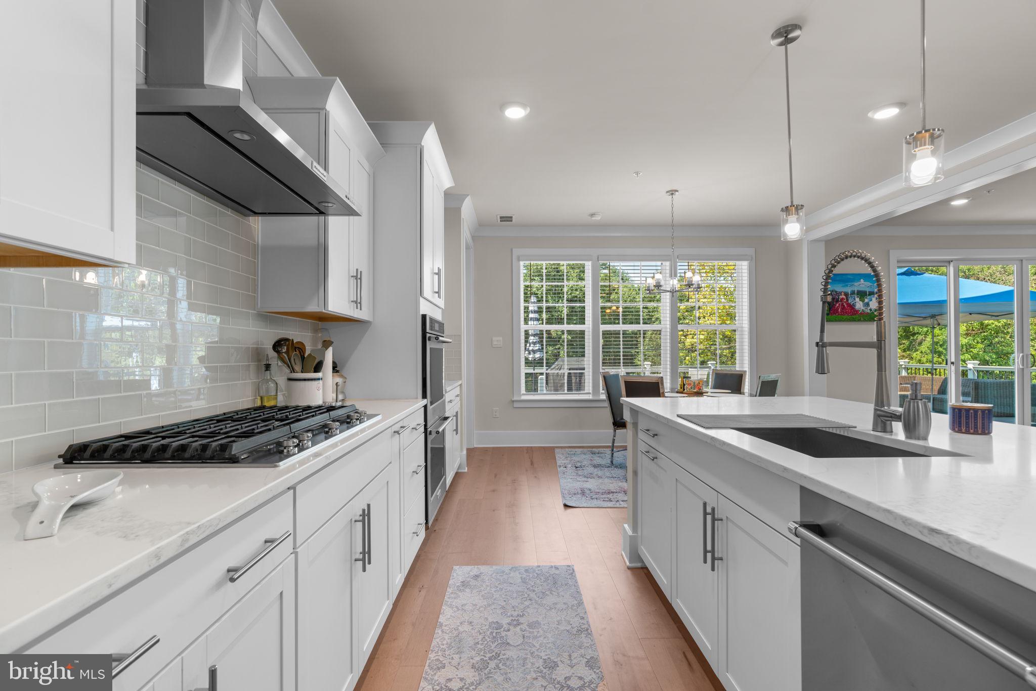 21708 Woodfield Road Gaithersburg, MD 20882 - Photo 11 of 76 a kitchen with stainless steel appliances a sink stove and cabinets