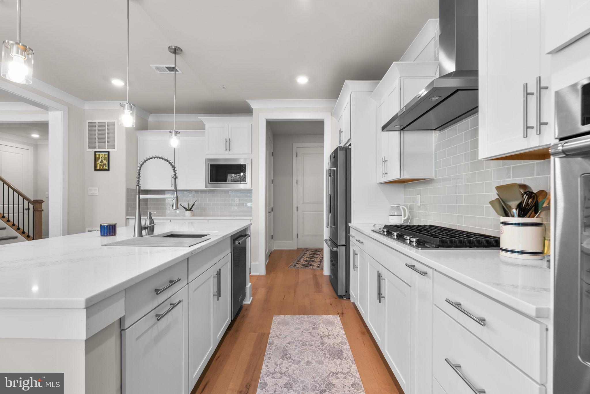 21708 Woodfield Road Gaithersburg, MD 20882 - Photo 14 of 76 a kitchen with stainless steel appliances granite countertop a sink stove and cabinets