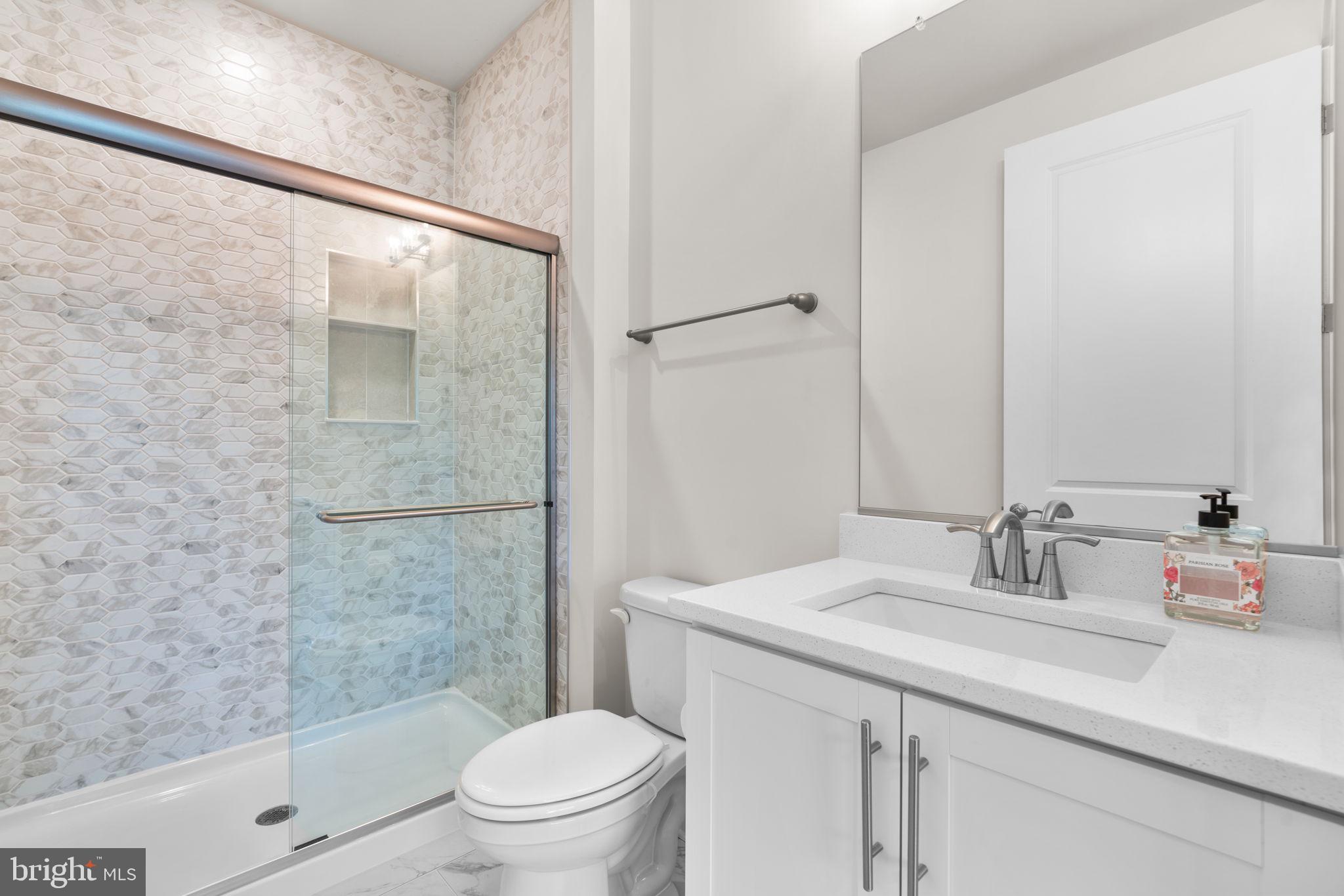 21708 Woodfield Road Gaithersburg, MD 20882 - Photo 20 of 76 a bathroom with a sink a toilet and shower