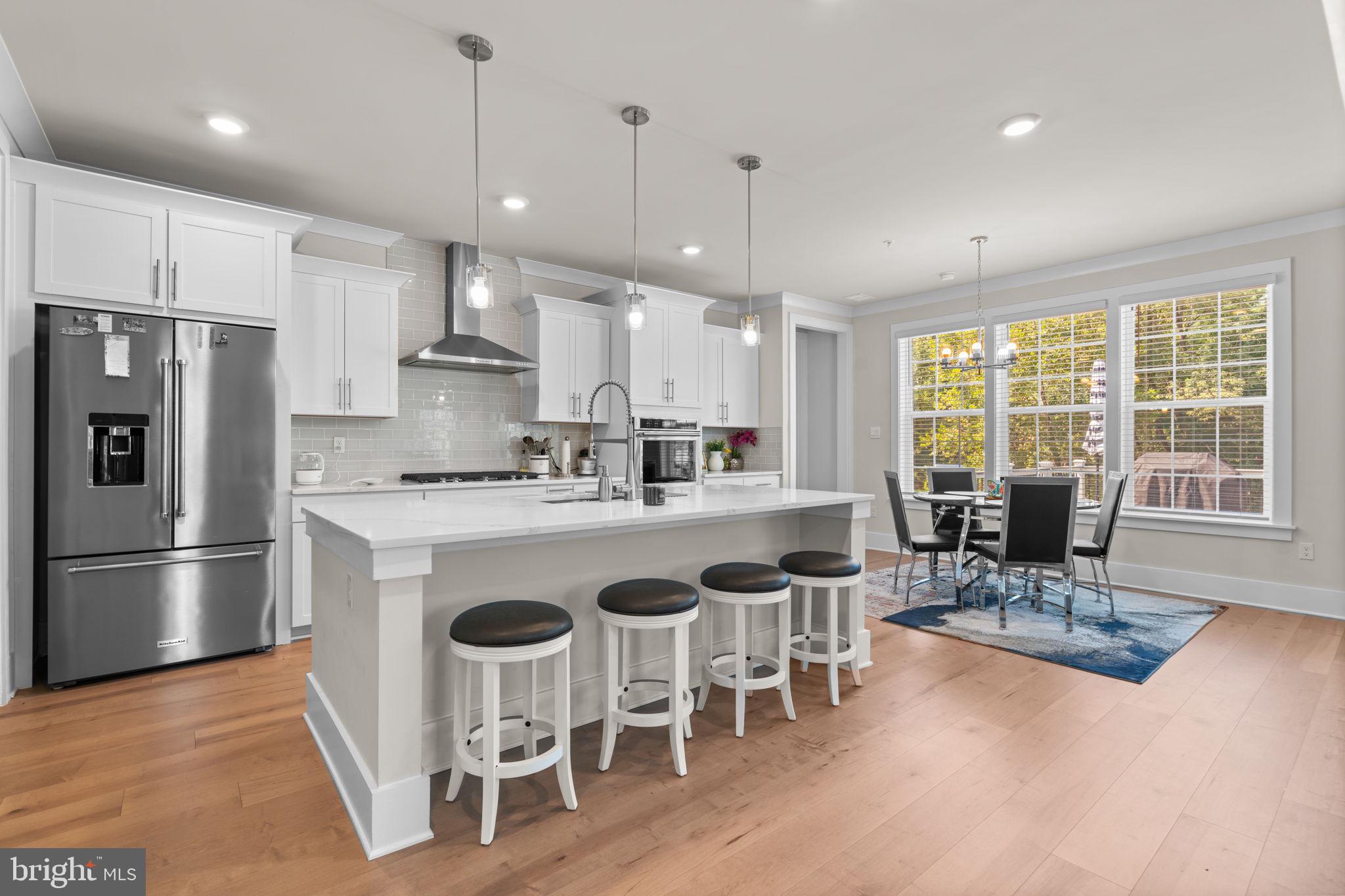 21708 Woodfield Road Gaithersburg, MD 20882 - Photo 2 of 76 a kitchen with stainless steel appliances granite countertop a stove a refrigerator a kitchen island a dining table and chairs