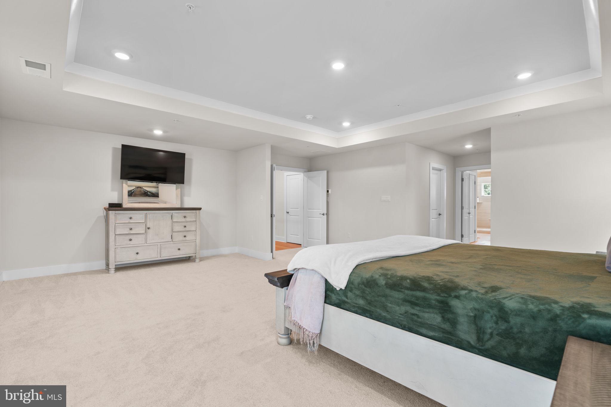 21708 Woodfield Road Gaithersburg, MD 20882 - Photo 26 of 76 a spacious bedroom with a bed and a flat screen tv
