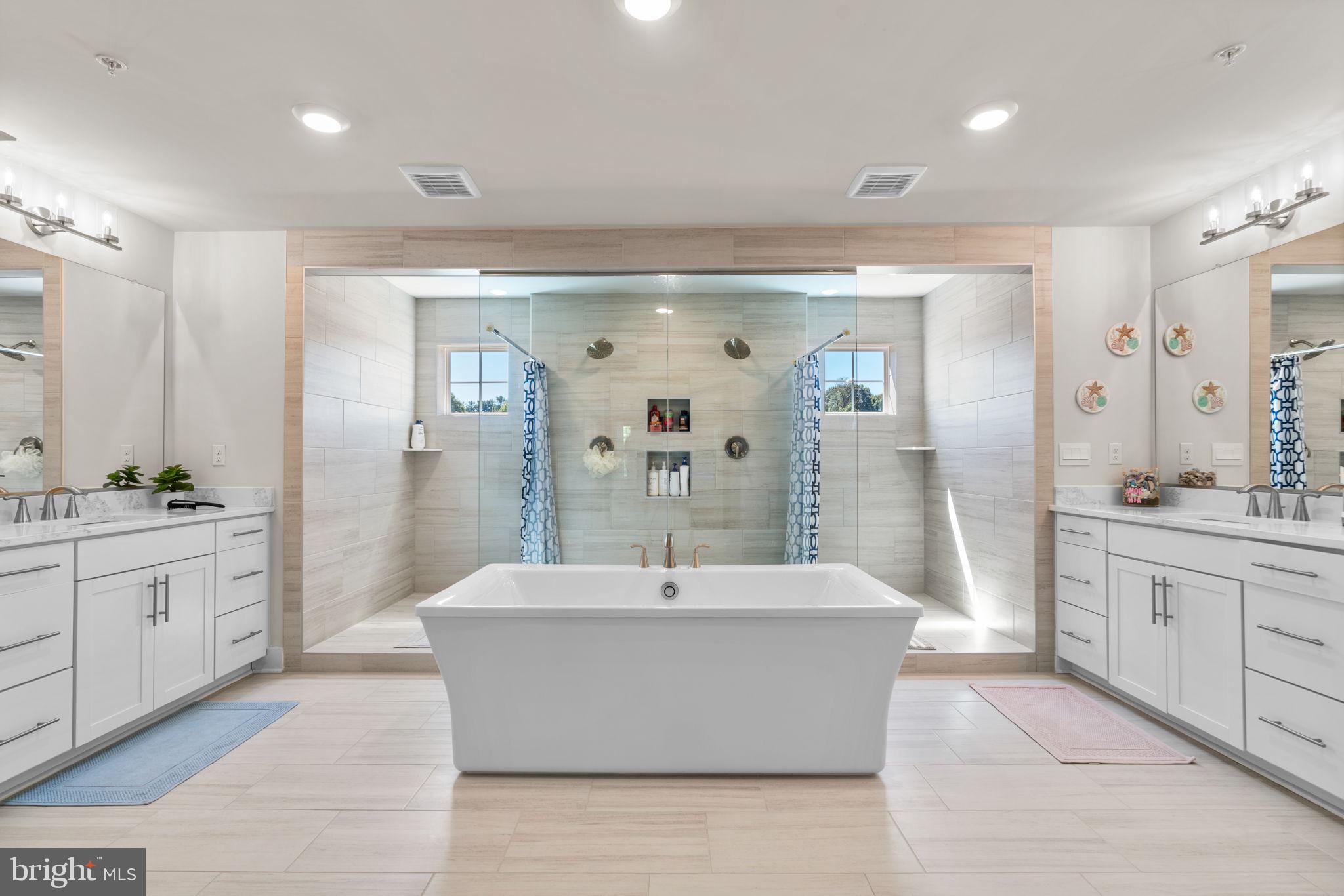 21708 Woodfield Road Gaithersburg, MD 20882 - Photo 27 of 76 a spacious bathroom with a double vanity sink a mirror and a shower