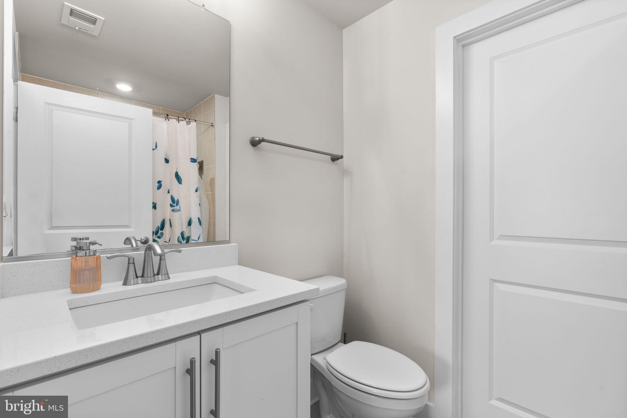 21708 Woodfield Road Gaithersburg, MD 20882 - Photo 34 of 76 a bathroom with a sink a toilet a shower and a mirror