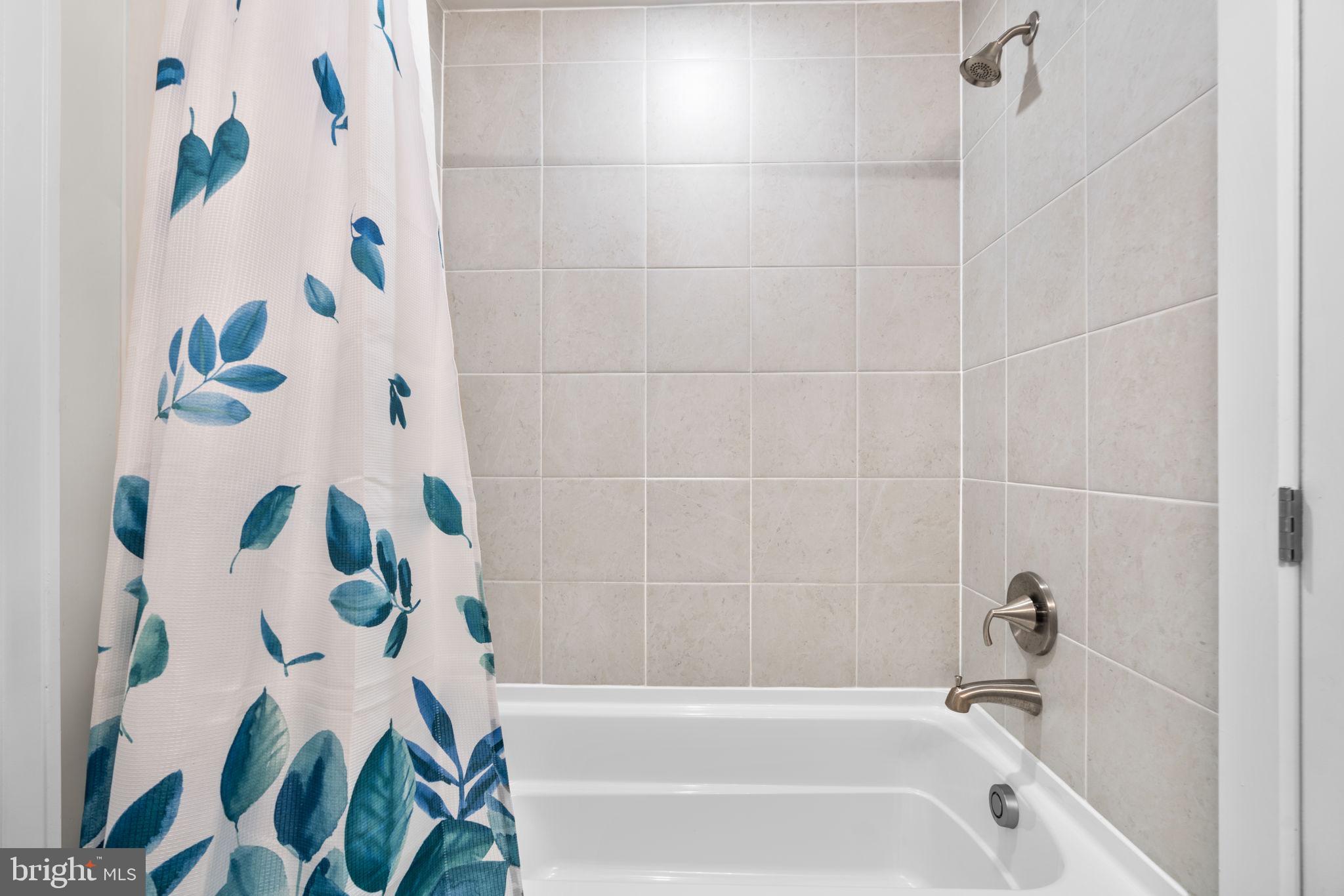 21708 Woodfield Road Gaithersburg, MD 20882 - Photo 35 of 76 a bathroom with a bathtub and a shower