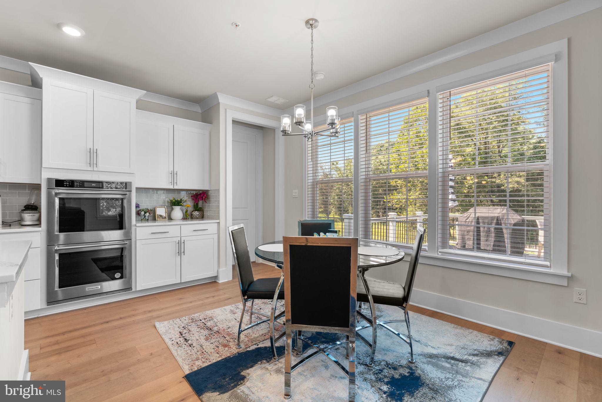21708 Woodfield Road Gaithersburg, MD 20882 - Photo 6 of 76 a dining room with furniture a chandelier and wooden floor