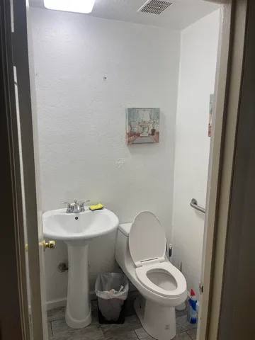 a bathroom with a sink toilet and a mirror