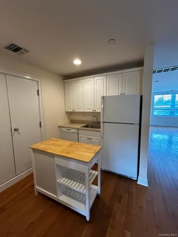 a kitchen with stainless steel appliances granite countertop a refrigerator a sink and a stove