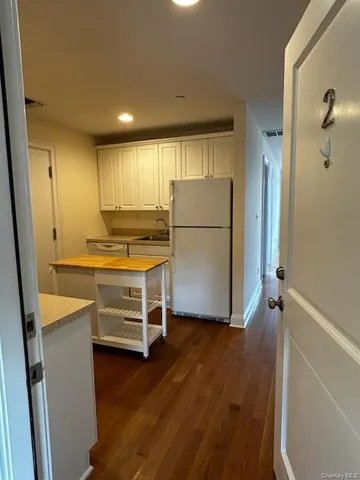 a room with wooden floors and white appliances