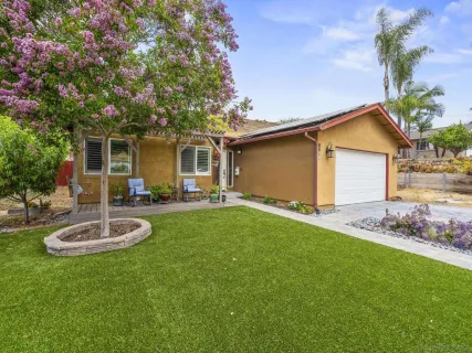 a view of a house with backyard and sitting area
