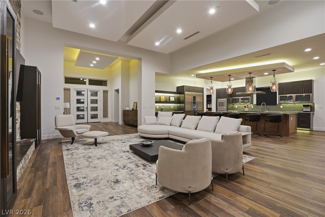 2224 Ledge Rock Lane Henderson, NV 89052 - Photo 13 of 66 Living room with vaulted ceiling, fireplace, open concept layout with surround sound, pocket & stacking doors, and accent lighting throughout