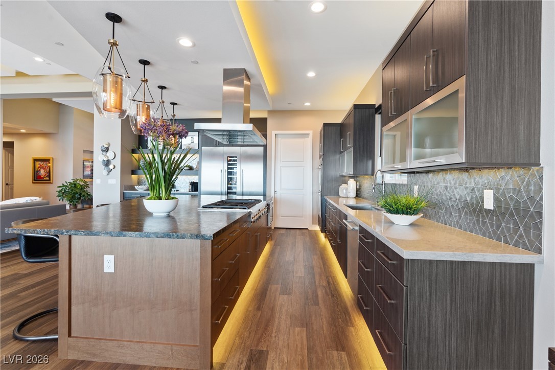 2224 Ledge Rock Lane Henderson, NV 89052 - Photo 16 of 66 Elevated gourmet kitchen with accent lighting, oversized leathered granite island, Thermador appliances, mosaic tile backsplash, double oven, and seamless indoor outdoor living