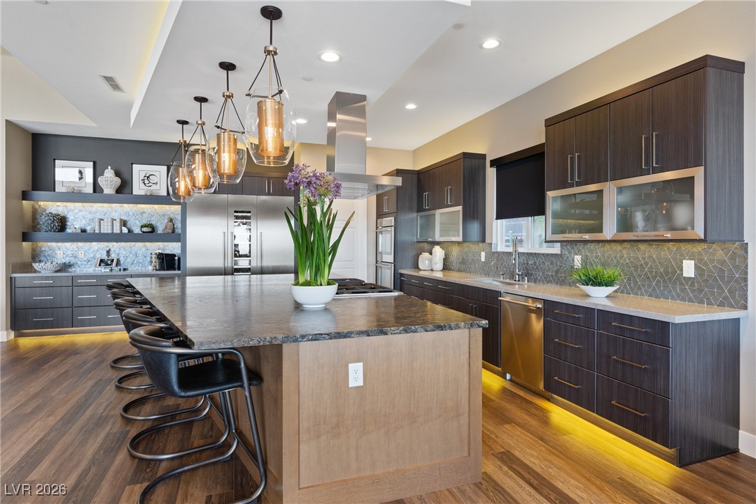 2224 Ledge Rock Lane Henderson, NV 89052 - Photo 17 of 66 Elevated gourmet kitchen with accent lighting, oversized leathered granite island, Thermador appliances, mosaic tile backsplash, double oven, and seamless indoor outdoor living