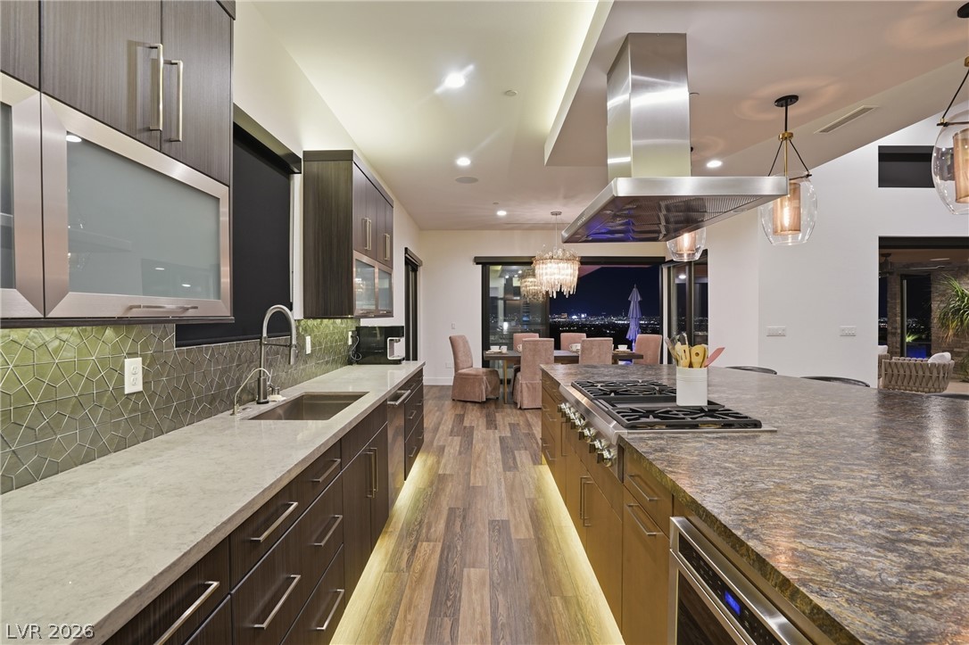 2224 Ledge Rock Lane Henderson, NV 89052 - Photo 19 of 66 Elevated gourmet kitchen with accents lighting, oversized leathered granite island, Thermador appliances, mosaic tile backsplash, double oven, and seamless indoor outdoor living