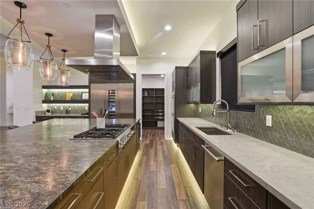 2224 Ledge Rock Lane Henderson, NV 89052 - Photo 21 of 66 Elevated gourmet kitchen with accents lighting, oversized leathered granite island, Thermador appliances, mosaic tile backsplash, double oven, and seamless indoor outdoor living