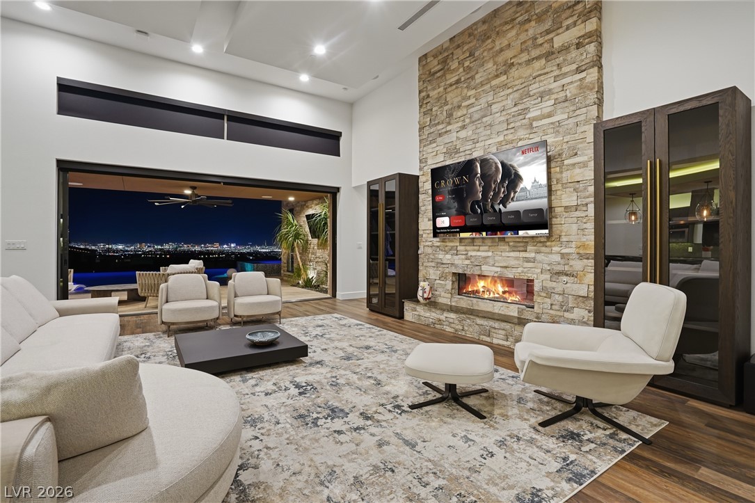 2224 Ledge Rock Lane Henderson, NV 89052 - Photo 7 of 66 Living room with vaulted ceiling, fireplace, open concept layout with surround sound, pocket & stacking doors, and accent lighting throughout