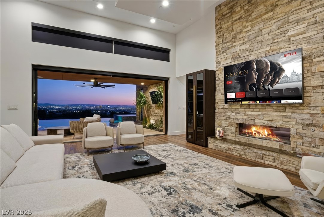 2224 Ledge Rock Lane Henderson, NV 89052 - Photo 8 of 66 Living room with vaulted ceiling, fireplace, open concept layout with surround sound, pocket & stacking doors, and accent lighting throughout