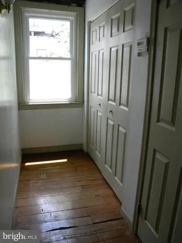 a view of a small space with wooden floor and a window