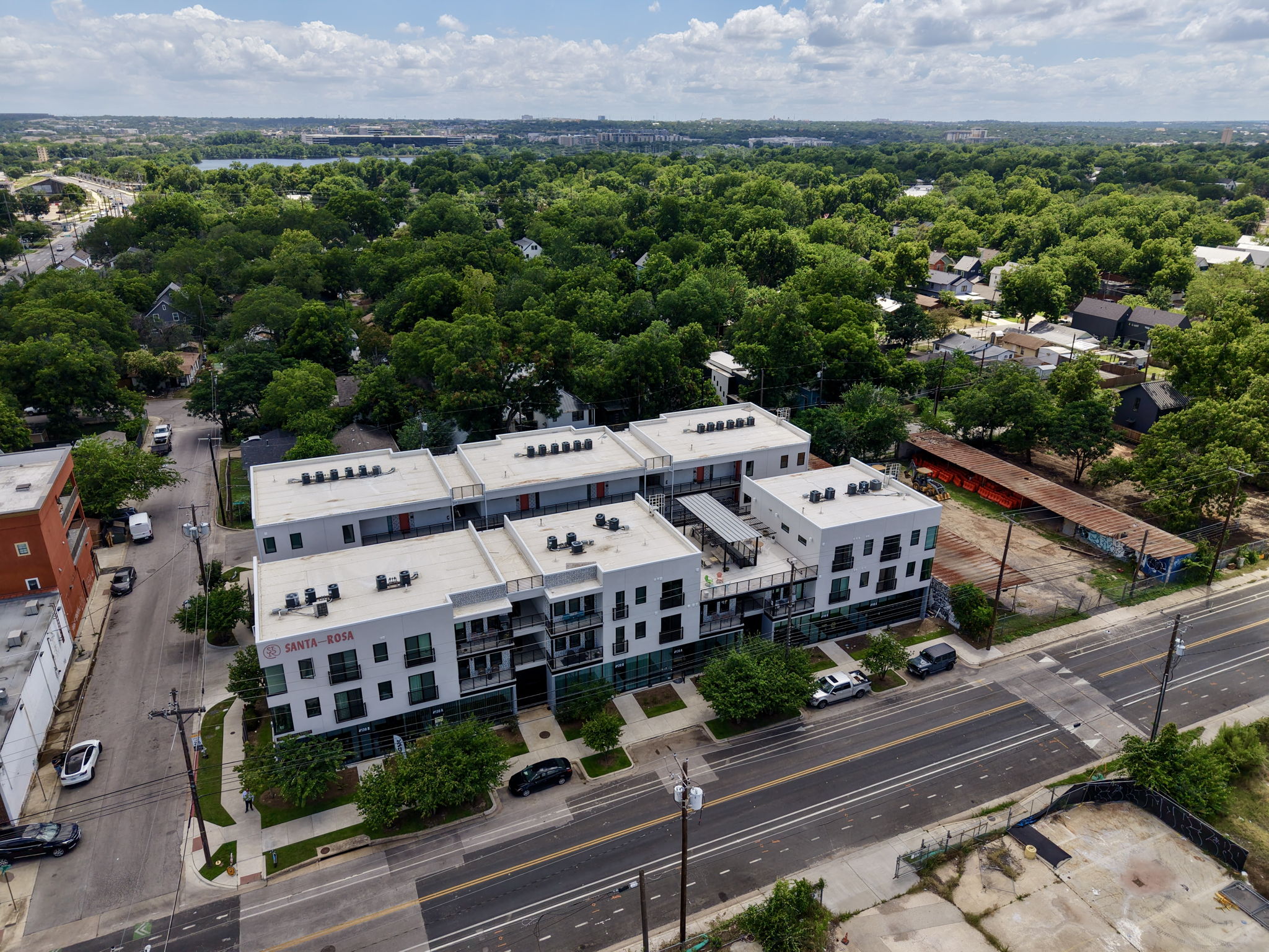 2709 East 5th Street, Unit 1306 Austin, TX 78702 - Photo 22 of 28 An aerial perspective reveals a modern multi-story building within a verdant urban setting, featuring balconies and contemporary design.