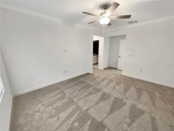 a view of an empty room with a ceiling fan