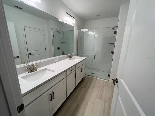 a spacious bathroom with a double vanity sink mirror double and shower