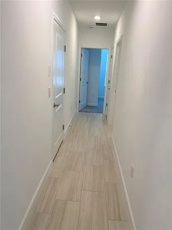 a view of a room with wooden floor and a hallway