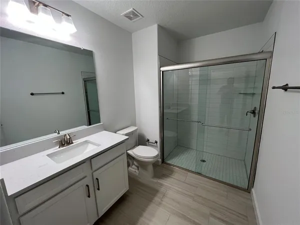 a bathroom with a double vanity sink toilet and shower