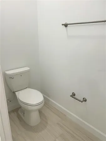 a white toilet sitting next to a shower