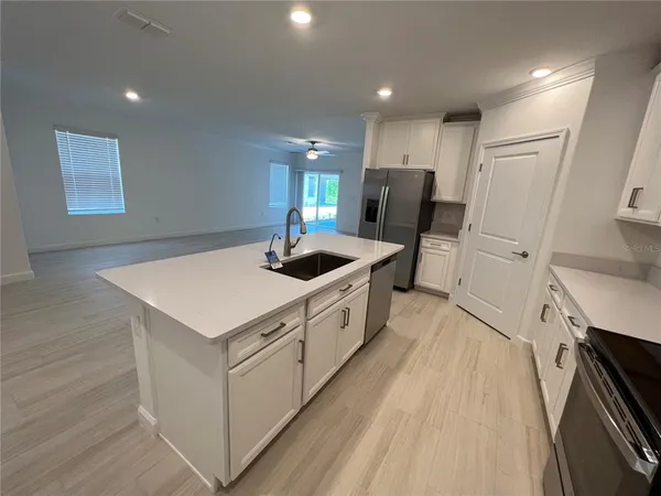 a kitchen with white cabinets and sink
