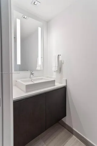 a bathroom with a sink vanity and mirror