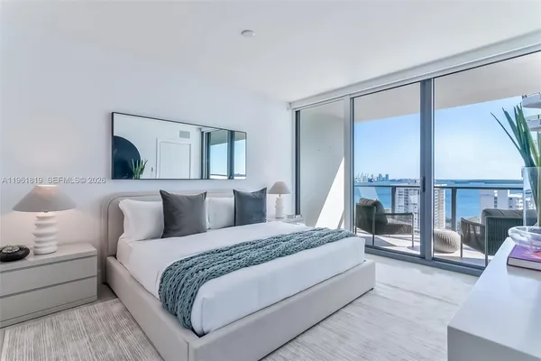 a large bedroom with a bed and large window