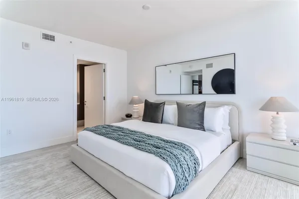 a bedroom with a bed and a lamp