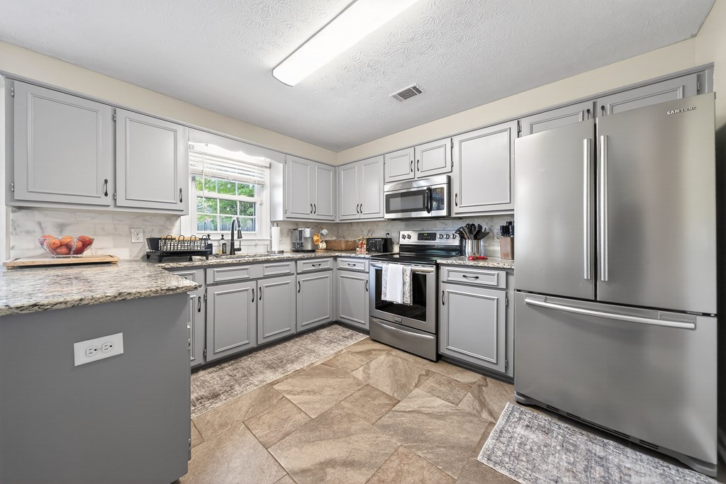 7333 Cedar Creek Loop Columbus, GA 31904 - Photo 11 of 37 a kitchen with granite countertop a refrigerator sink stainless steel appliances and cabinets
