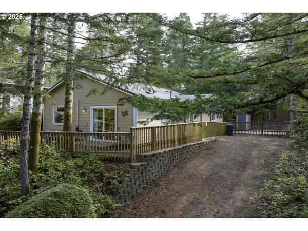 a view of a house with a small yard and a large tree