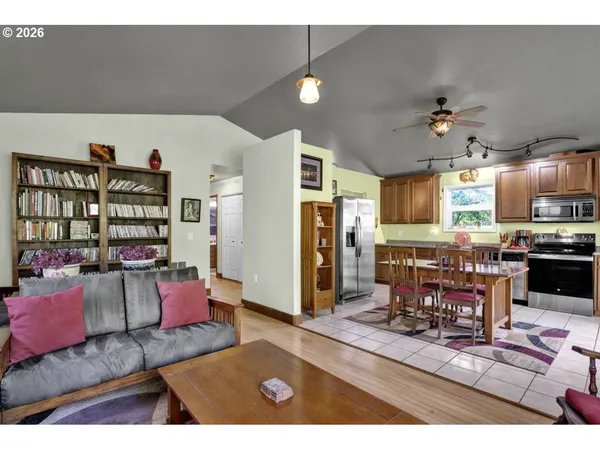a living room with furniture kitchen view and a chandelier