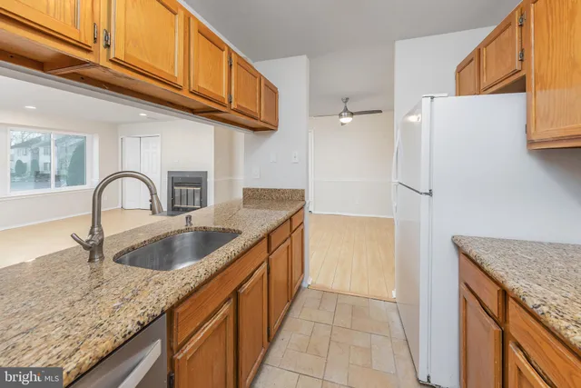 a kitchen with granite countertop a sink and a refrigerator